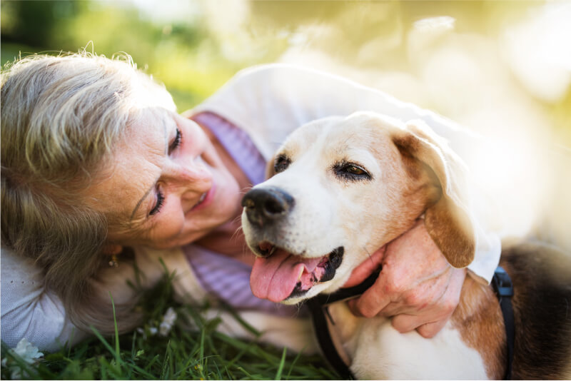 A woman cuddling her dog in a relaxed way, happy knowing that digital biomarkers can change the healthcare landscape.