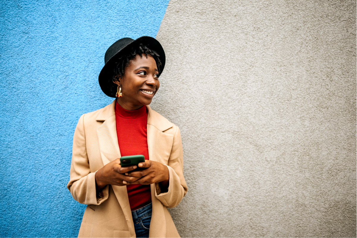 Woman holding her smartphone and smiling.
